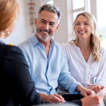 Happy mature couple meeting investments and financial advisor at home.