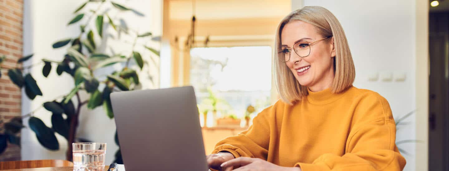 A woman with glasses using a laptop.