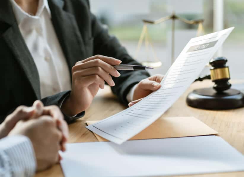 Image of two people (from neck down) reviewing a contract.