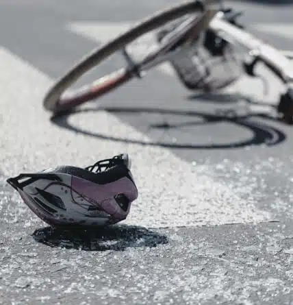 A close up of a bicycle accident with a helmet on the ground