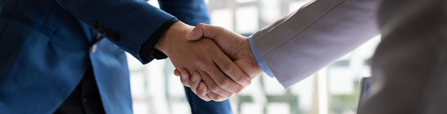 A close up of two men shaking hands